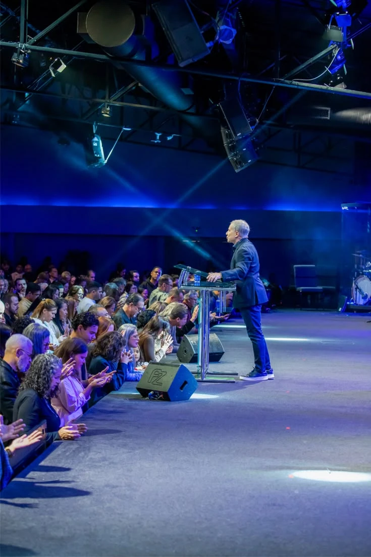 A speaker addresses an audience from a stage.