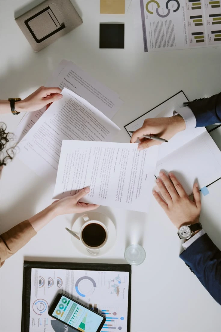 Hands review professional documents, charts and written evidence.