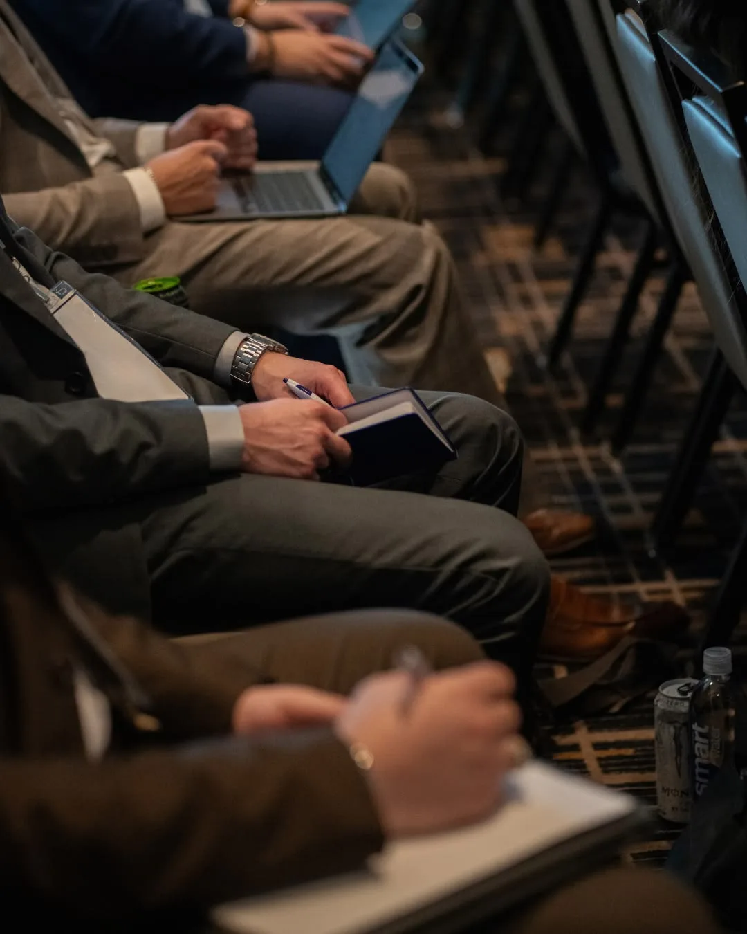 Participants record observations in notebooks during a professional session.