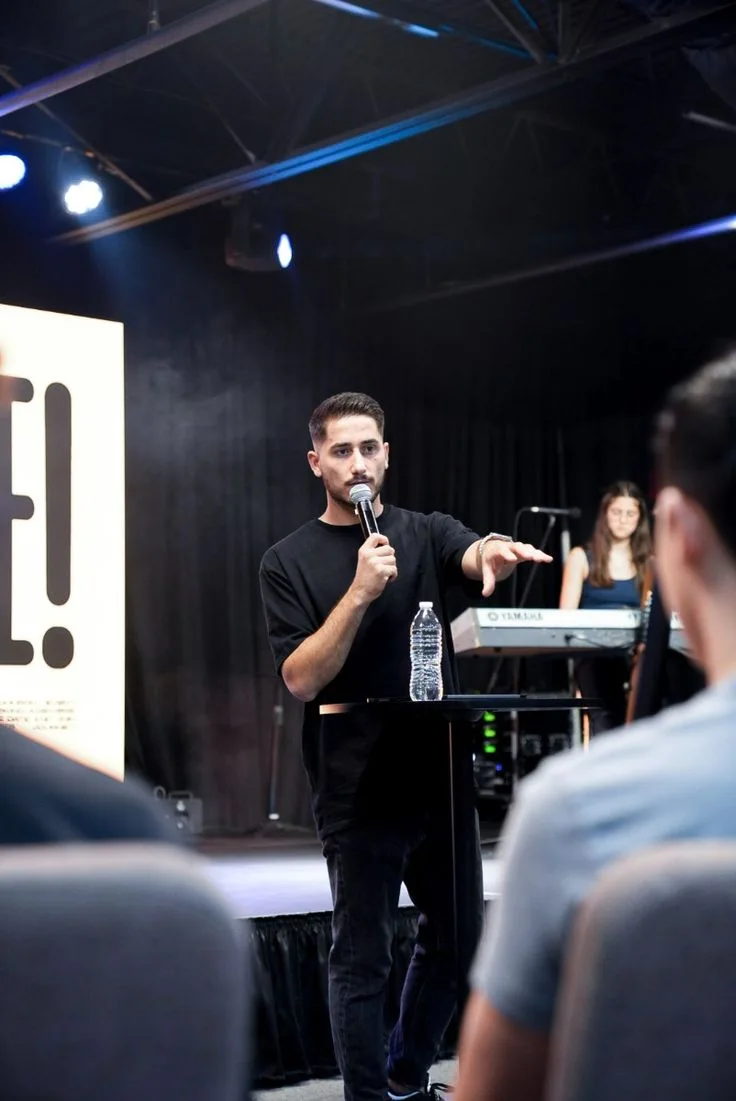 An emerging speaker addresses an audience with a microphone.