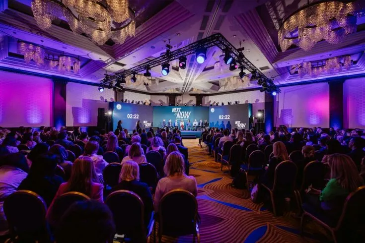 A large audience attends a professional conference event.