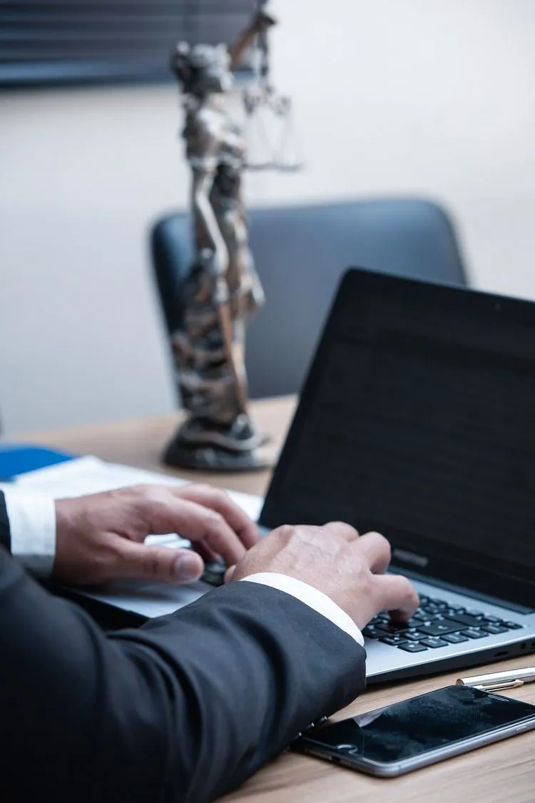 A professional works on a laptop with planning materials nearby.